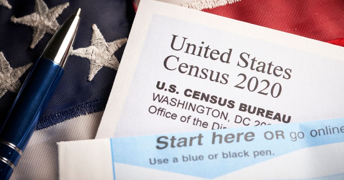 The above stock photo shows a 2020 Census survey questionnaire with an American flag.