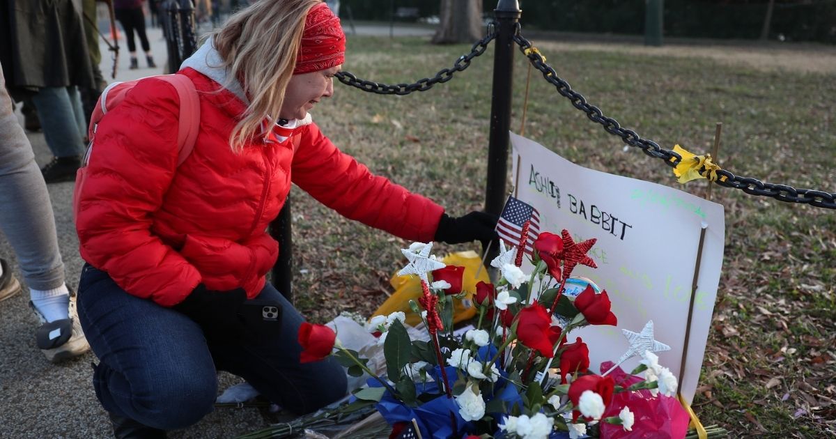A woman becomes emotional as she visits a memorial set up near the U.S. Capitol Building for Ashli Babbitt, who was killed in the building after a pro-Trump mob broke in the day prior on Jan. 7, 2021, in Washington, D.C.