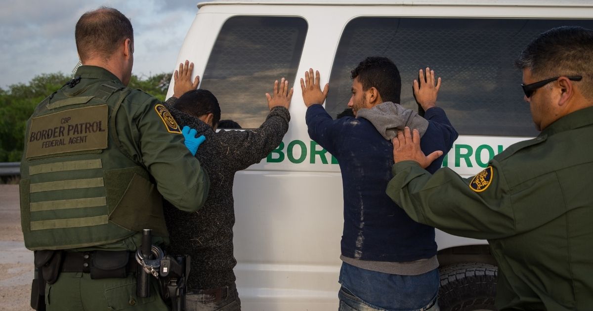 Border Patrol agents apprehend illegal immigrants shortly after they crossed the border from Mexico into the United States on March 26, 2018, in the Rio Grande Valley Sector near McAllen, Texas.