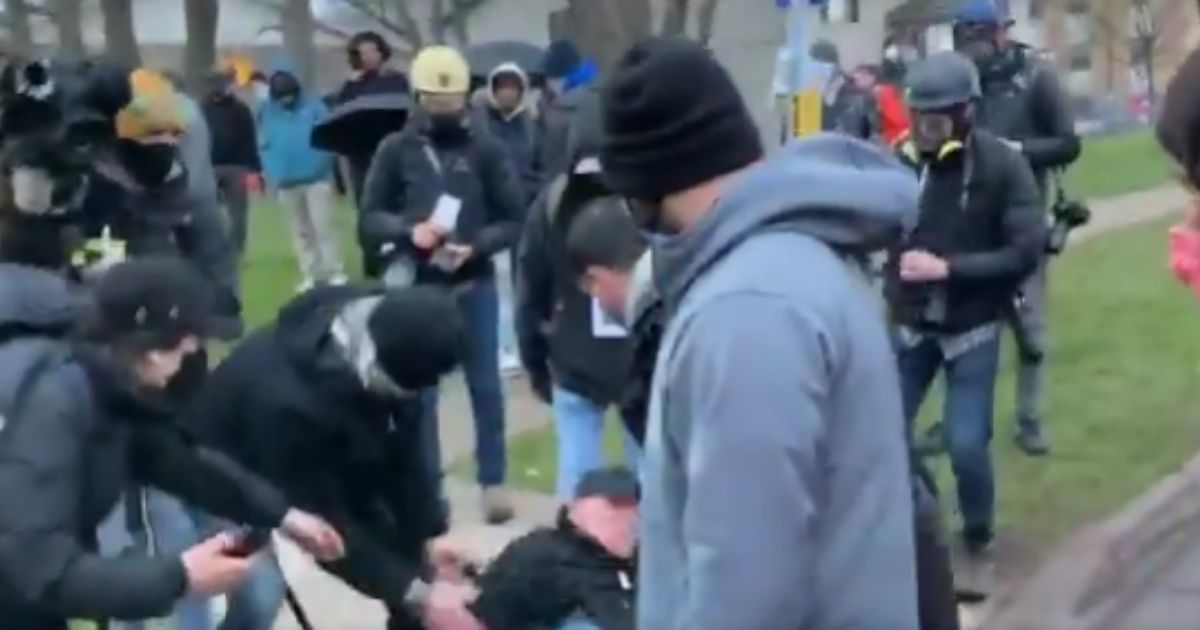 Protesters throw a water bottle at a CNN crew member and hit him in the head in Brooklyn, Minnesota.