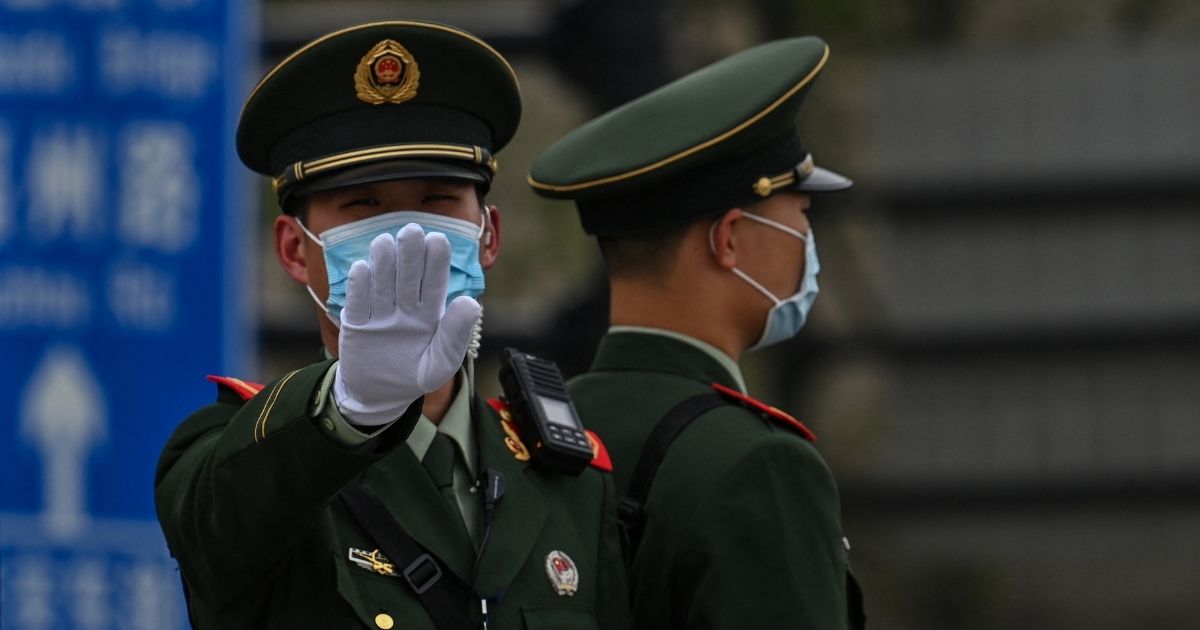 A Chinese paramilitary police officer gestures on the promenade of the Bund along the Huangpu River in Shanghai on April 16.