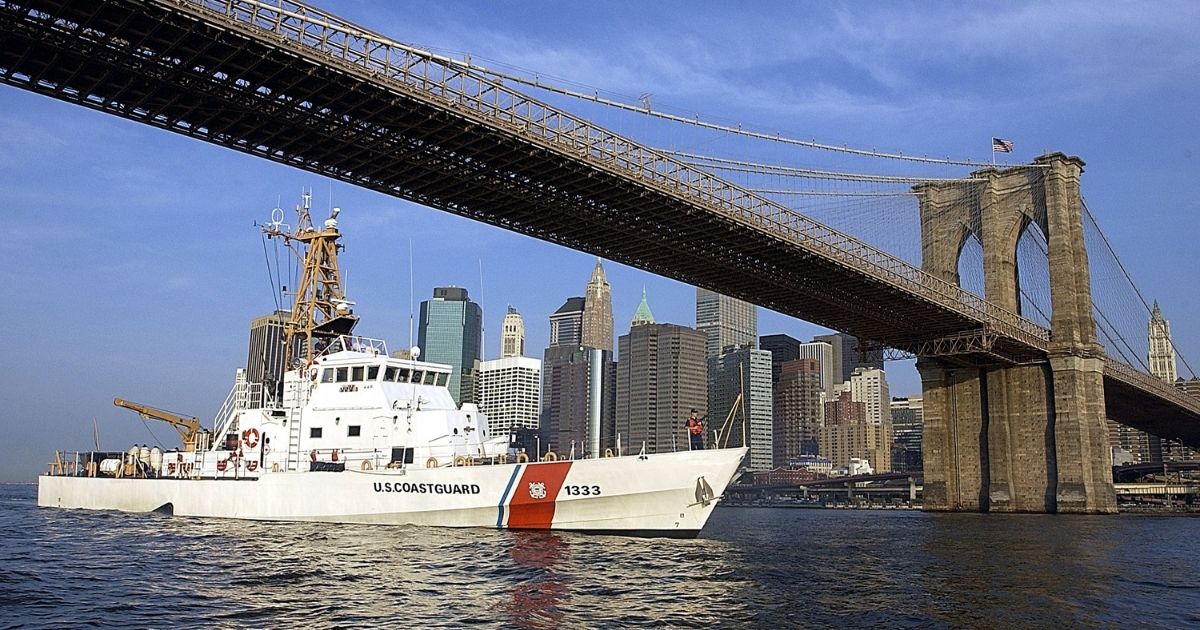 The Coast Guard Cutter Adak patrols past the Brooklyn Bridge along the East River in New York City on Aug. 22, 2002.