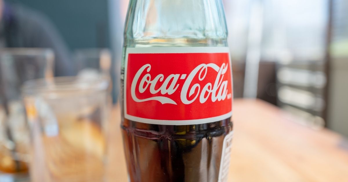 This photo portrays a close-up of the logo for Coca-Cola on a glass bottle in a restaurant setting in Walnut Creek, California, on March 4, 2021.