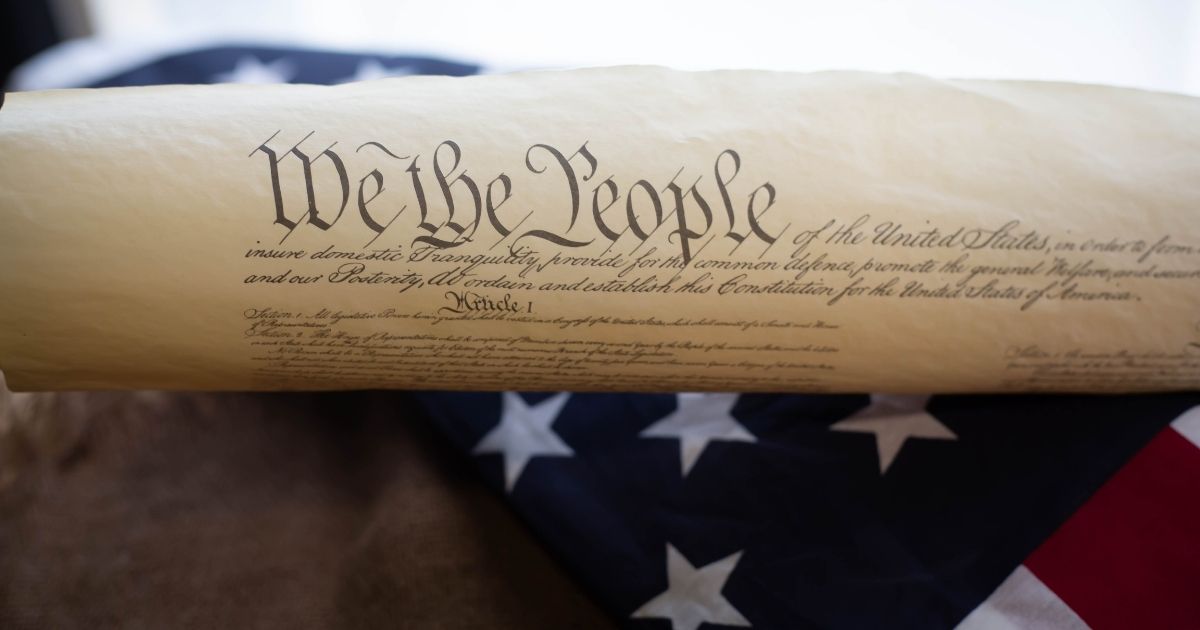 The Constitution is pictured on an American flag in the stock image above.