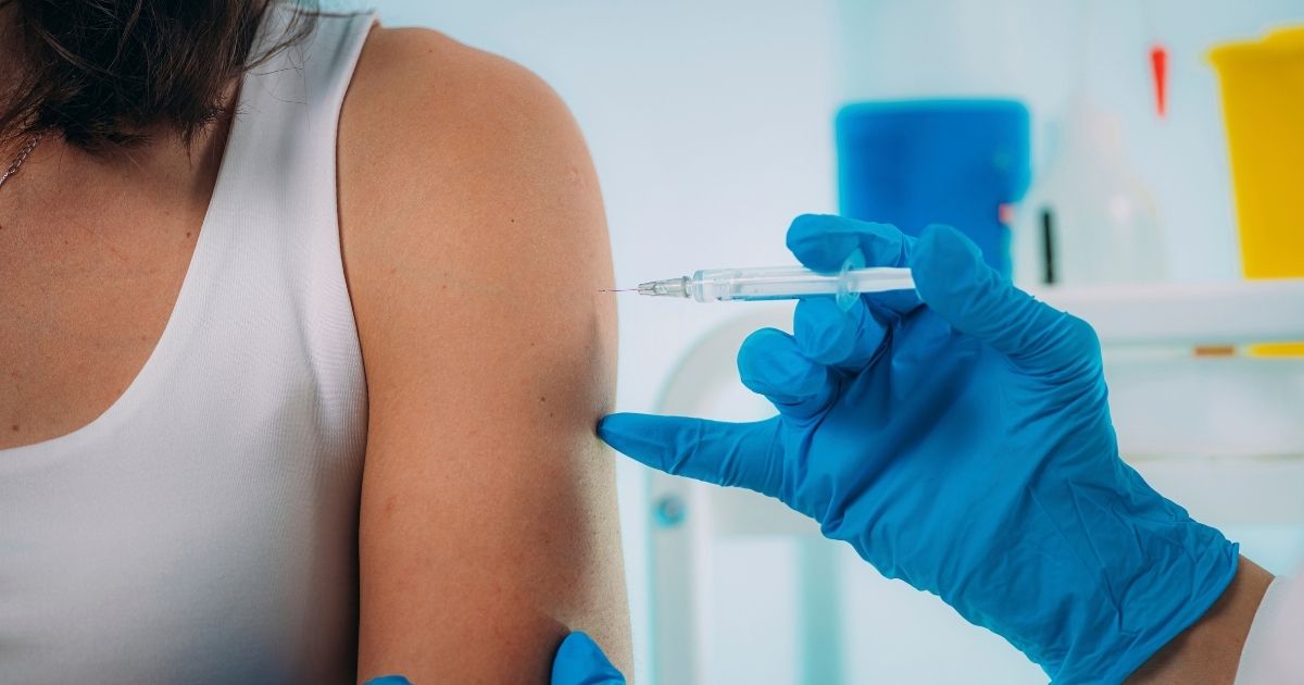 The above stock photo shows a woman being vaccinated.