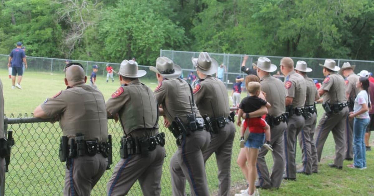 Troopers from the Texas Department of Public Safety attend their wounded colleague's son's baseball game on Tuesday.