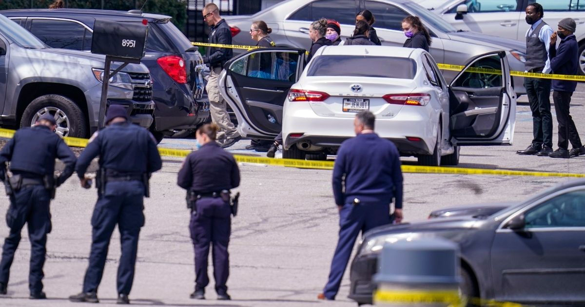 Law enforcement officers confer at the scene on Friday in Indianapolis, where multiple people were shot at a FedEx Ground facility near the Indianapolis airport.