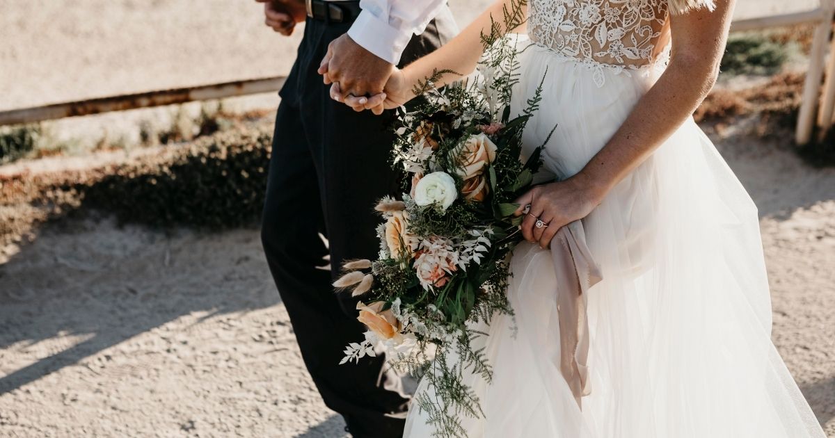 The above stock photo shows a close-up of a bride and groom walking.