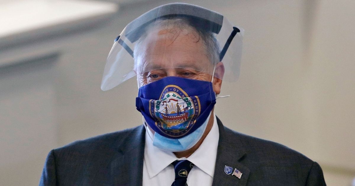 Terry Pfaff, chief operating officer of the New Hampshire General Court, wears a face shield and a protective mask adorned with a design of the state seal prior to a session at the State House in Concord on June 16.