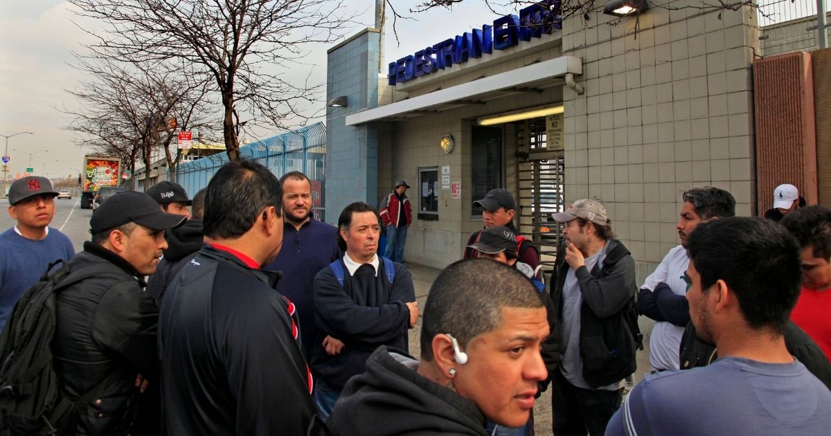 Mexican workers stand outside the Hunts Point Food Distribution Center at the end of their overnight shift in the Bronx, New York, on March 13, 2012.