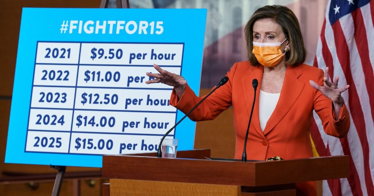 House Speaker Nancy Pelosi stands beside a chart outlining a path to a $15-per-hour minimum wage during her weekly news conference at the Capitol in Washington on March 11.