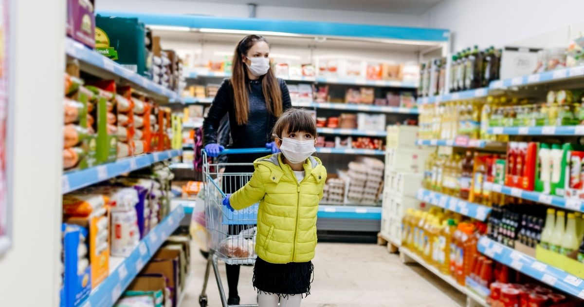 A mother and her daughter wear masks in the stock image above.