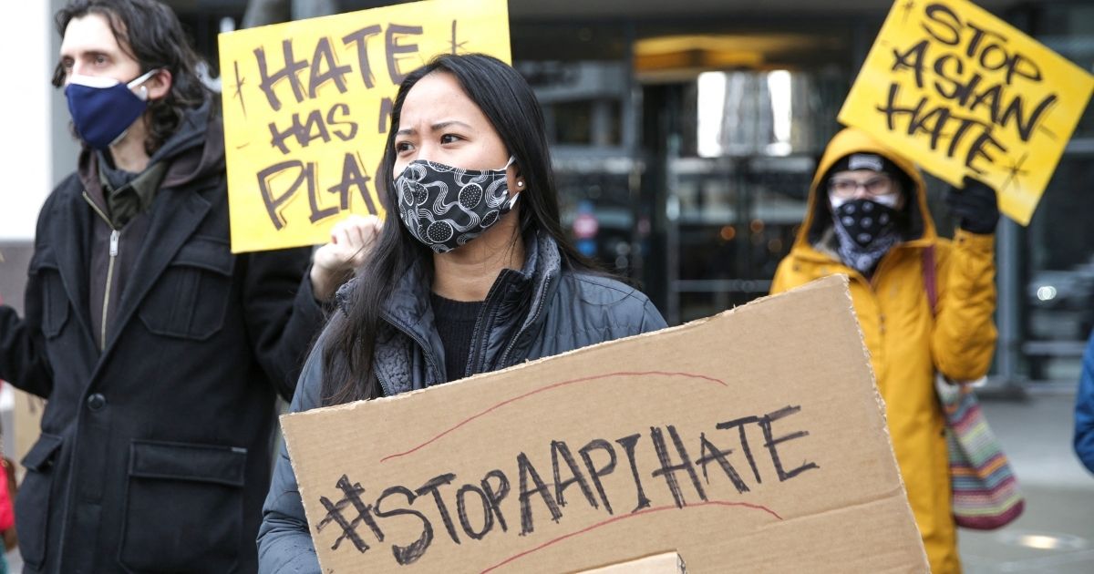 Trish Villanueva (center) of Seattle holds a sign with the hashtag "stop AAPI hate" during the We Are Not Silent rally organized by the Asian American Pacific Islander (AAPI) Coalition Against Hate and Bias in Bellevue, Washington, on March 18, 2021.