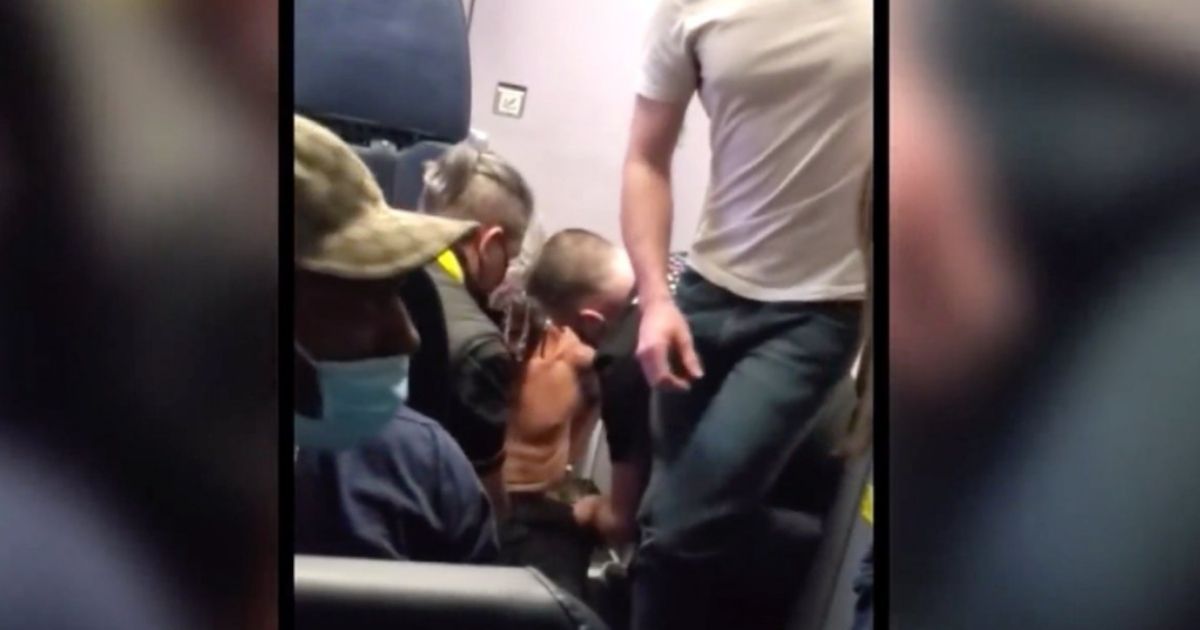 A shirtless passenger on Spirit Airlines flight 185 is restrained after he apparently tried to open an exit door during the flight from Cleveland to Los Angeles on March 24, 2021.