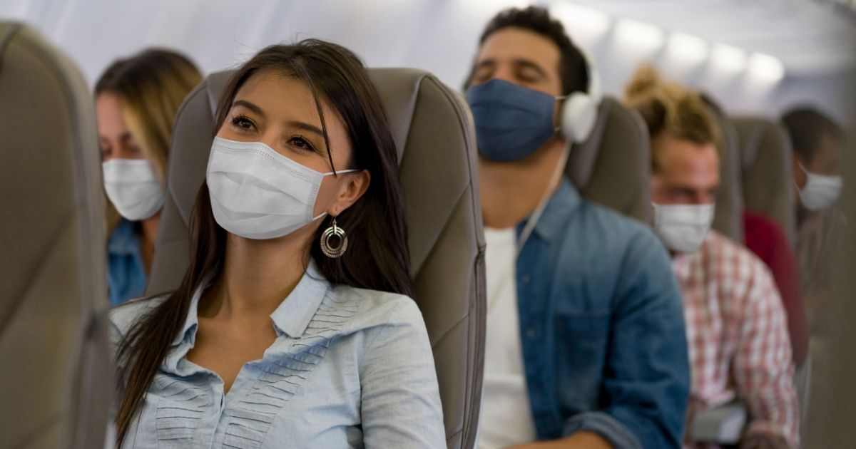 Airline passengers wear face coverings while traveling during the COVID-19 pandemic.