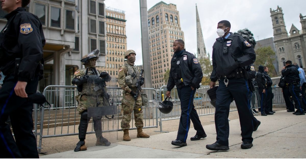 Police officers walk past as members of the National Guard patrolling the city in an October file photo,