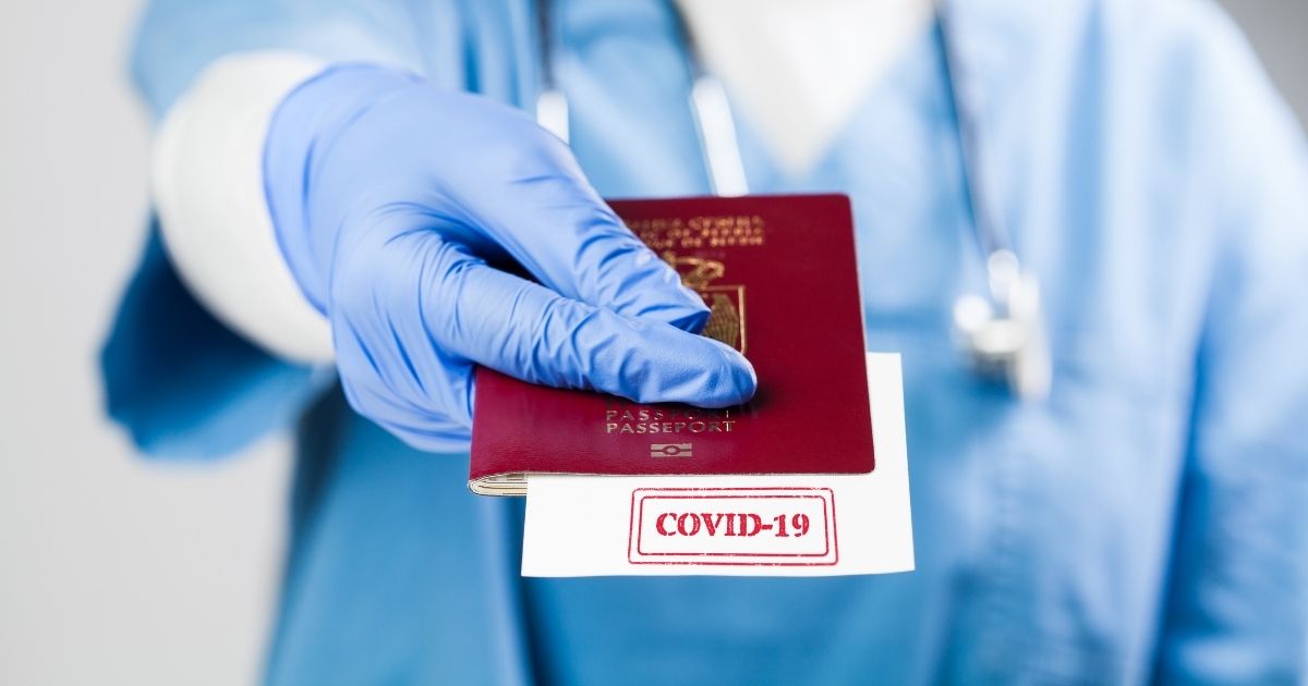 A health professional is seen holding a COVID vaccine "passport" in the stock image above.