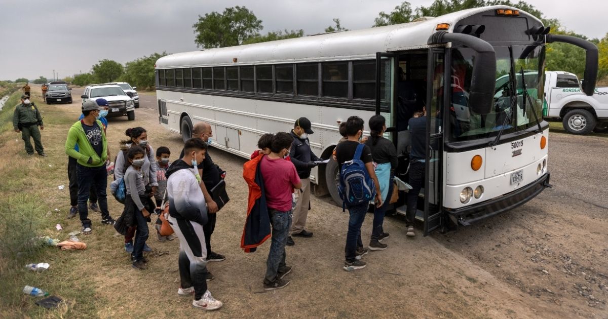 Central American migrants board a US Customs and Border Protection bus after crossing the border from Mexico on April 13, 2021, in La Joya, Texas.