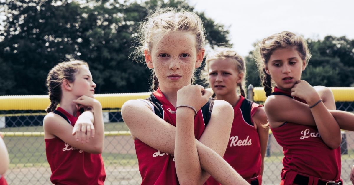 Young softball players warm up in the above stock image.