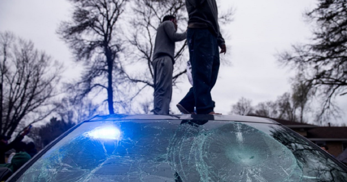 Rioters stand on a police cruiser in Brooklyn Center, Minnesota as violence erupted after a fatal police shooting of a man during a traffic stop Sunday.