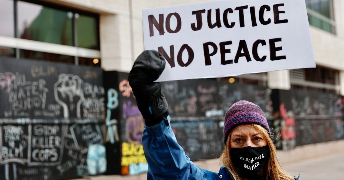 A protester holds a sign outside the courthouse in Minneapolis on April 19, 2021, during the trial of former police officer Derek Chauvin.
