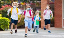 Schoolchildren are pictured wearing masks outside in the stock image above.