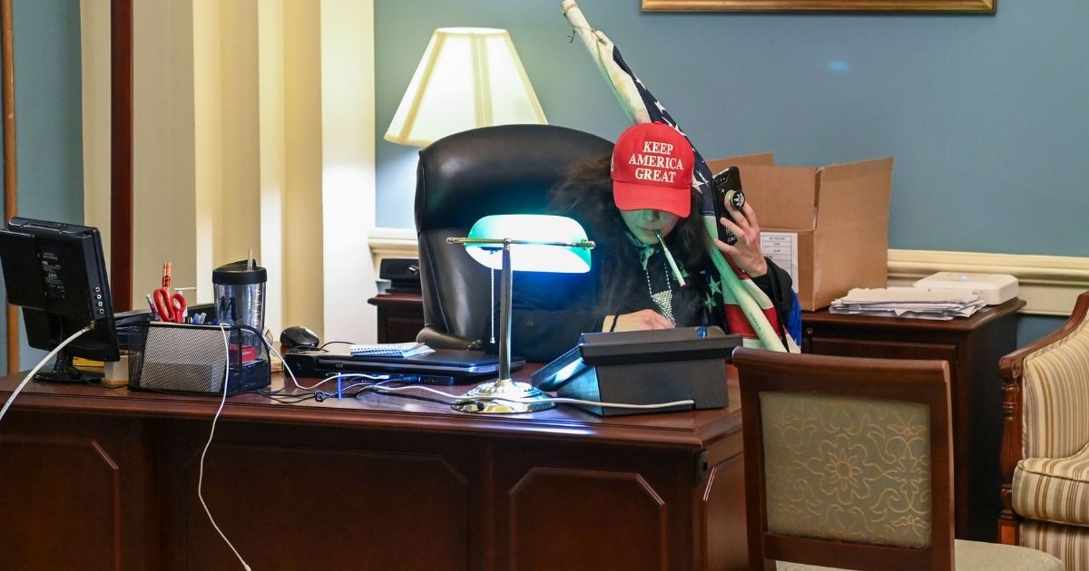 A rioter sits inside the office of Speaker of the House Nancy Pelosi inside the US Capitol in Washington, D.C., on Jan. 6, 2021.