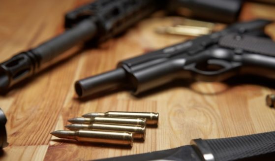 Firearms are pictured on a table in the stock image above.