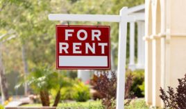 A 'For Rent' sign in a front yard.