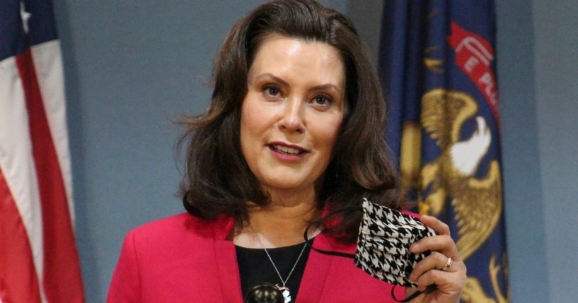 Michigan Gov. Gretchen Whitmer holds a face mask while speaking during a news conference in Lansing on May 21, 2020.