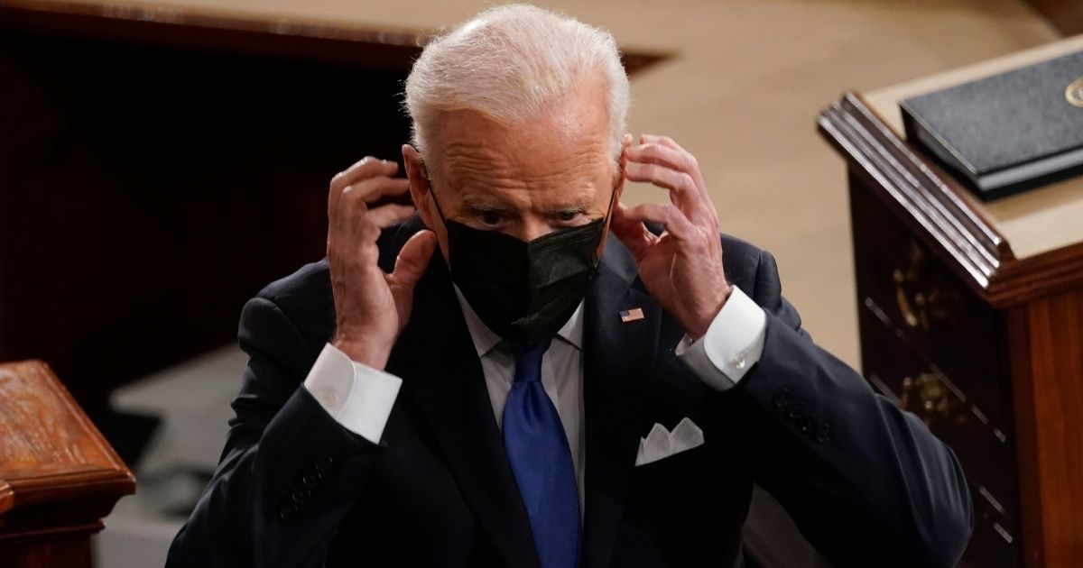 President Joe Biden puts his face mask on after speaking to a joint session of Congress in the House chamber of the U.S. Capitol on Wednesday in Washington, D.C.