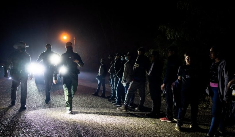 After crossing the Rio Grande River, migrants wait to be processed by Border Patrol officers on April 24 in Roma, Texas.