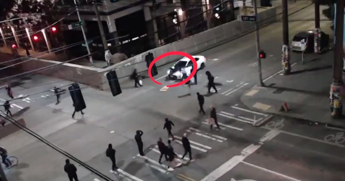 Surveillance footage of an intersection outside the East Precinct from Saturday evening shows a driver's response to antifa protesters blocking off the roadway.