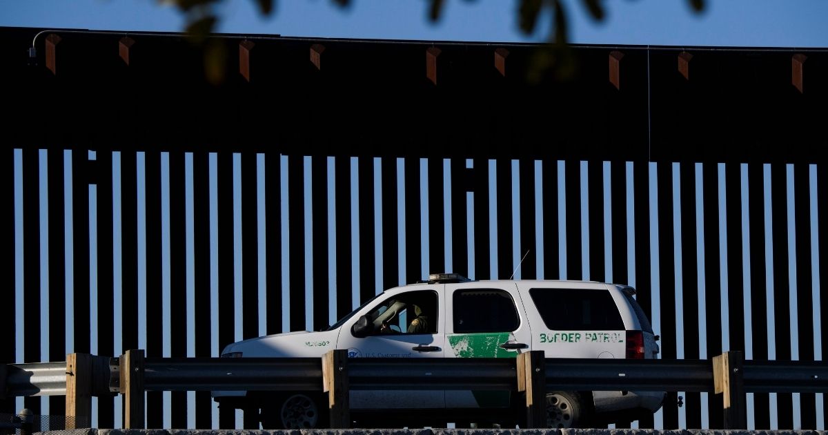 A Border Patrol agent sits in a vehicle along a border wall near the San Ysidro Port of Entry at the U.S.-Mexico border on Feb. 19, 2021, in San Diego.