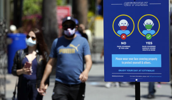 In this Friday photo, signs instruct visitors on the proper way to wear masks at the Universal City Walk in Universal City, California.