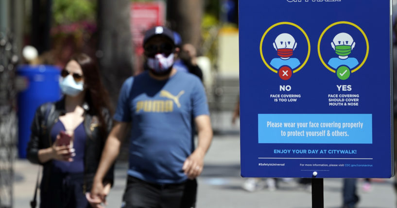 In this Friday photo, signs instruct visitors on the proper way to wear masks at the Universal City Walk in Universal City, California.