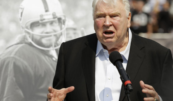 Former Oakland Raiders head coach John Madden speaks about former quarterback Ken Stabler, pictured at rear, at a ceremony honoring Stabler during halftime of an NFL football game between the Raiders and the Cincinnati Bengals in Oakland, California, on Sept. 13, 2015.