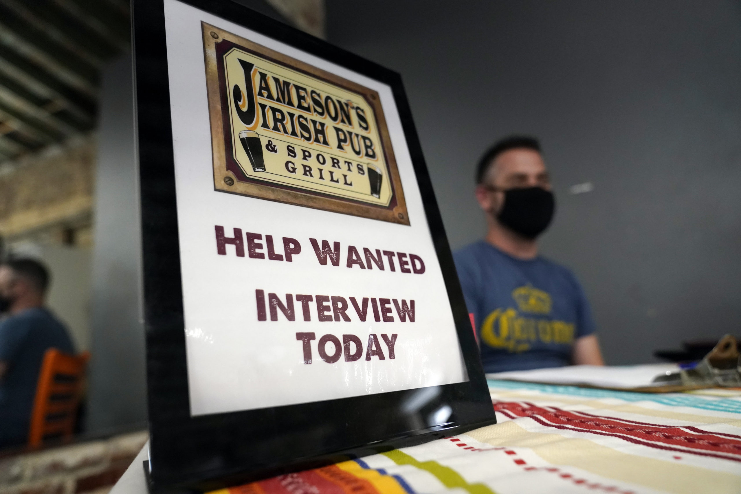 A hiring sign is shown at a booth for Jameson's Irish Pub during a job fair on Sept. 22, 2021, in the West Hollywood section of Los Angeles, California.