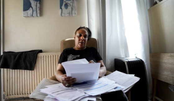 Jennifer Jones sorts her bills at her small flat in London on Thursday. Like millions of people, Jones, 54, is struggling to cope as energy and food prices skyrocket in Great Britain.