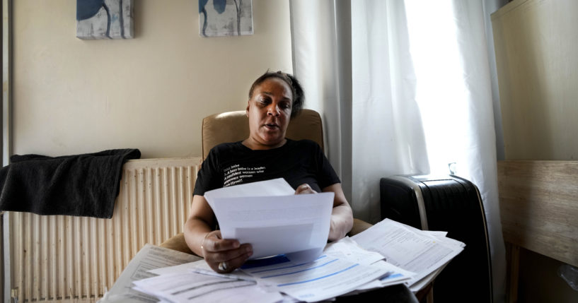 Jennifer Jones sorts her bills at her small flat in London on Thursday. Like millions of people, Jones, 54, is struggling to cope as energy and food prices skyrocket in Great Britain.