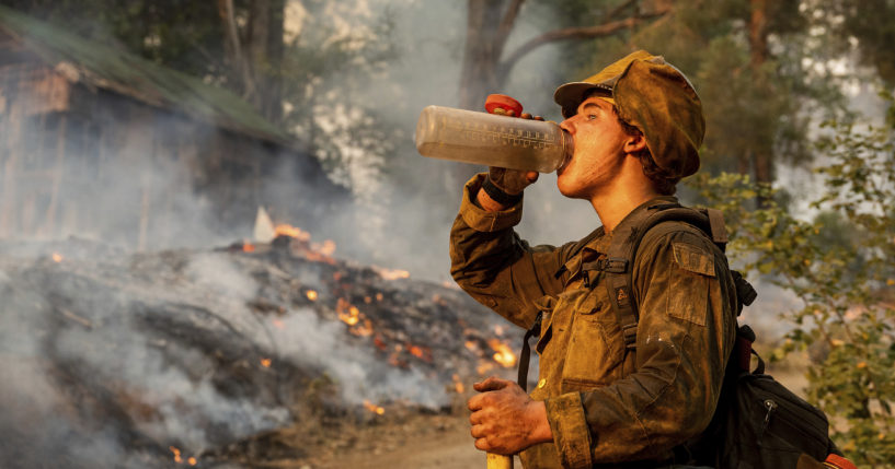 Firefighter Trapper Gephart of Alaska's Pioneer Peak Interagency Hotshot crew takes a drink while battling the Mosquito Fire in the Volcanoville community of El Dorado County, California, on Friday.