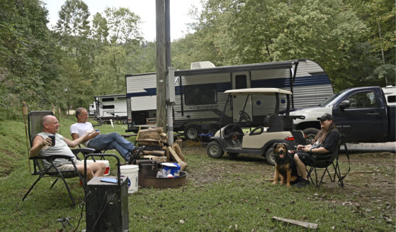 People displaced by floods in early July sit at their campsite at a state park in Prestonsburg, Kentucky, on Tuesday. The flood victims have been staying in travel trailers as they wait for workers to rebuild their homes.