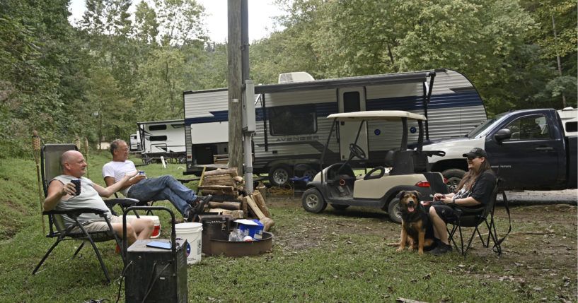 People displaced by floods in early July sit at their campsite at a state park in Prestonsburg, Kentucky, on Tuesday. The flood victims have been staying in travel trailers as they wait for workers to rebuild their homes.