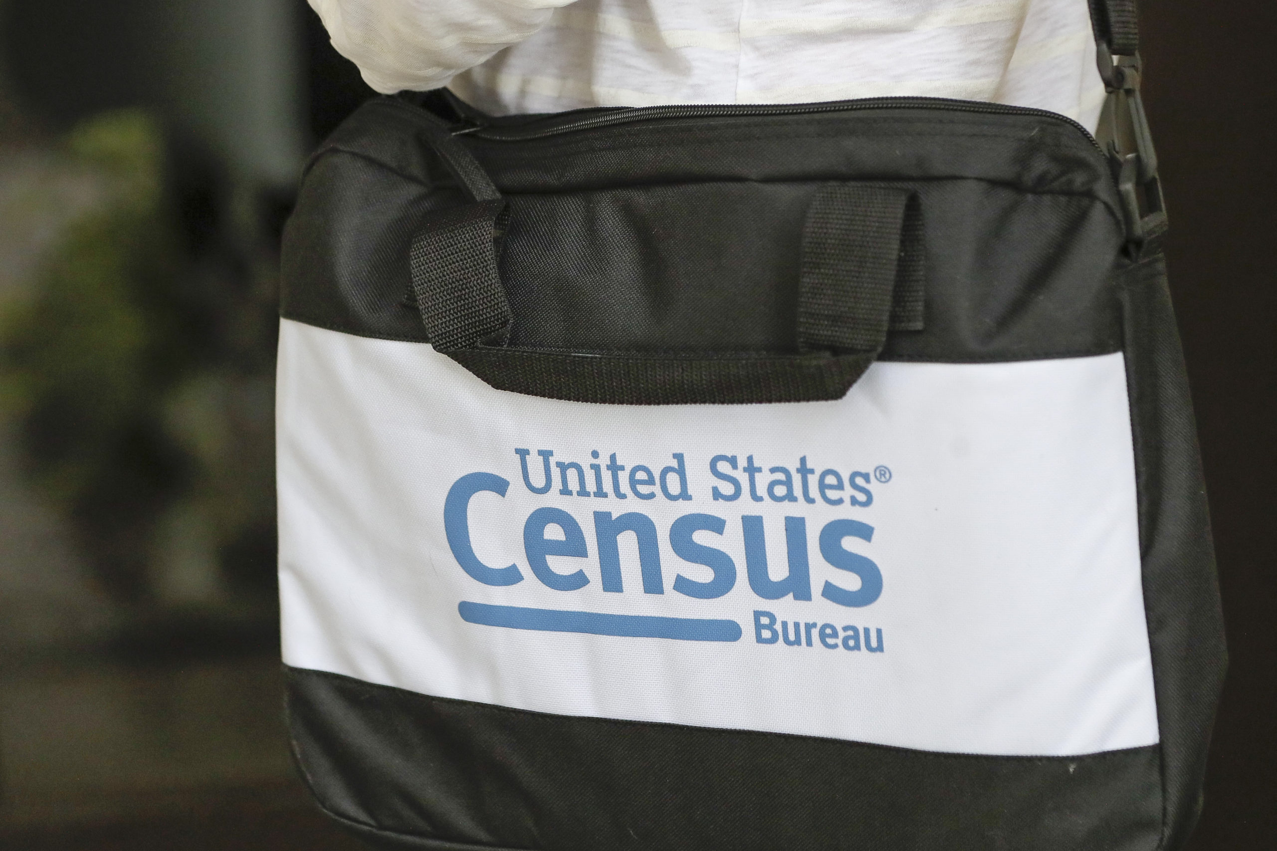 The bag of a U.S. Census Bureau census taker is pictured as he walks to a residence in Winter Park, Florida, on Aug. 11, 2020.