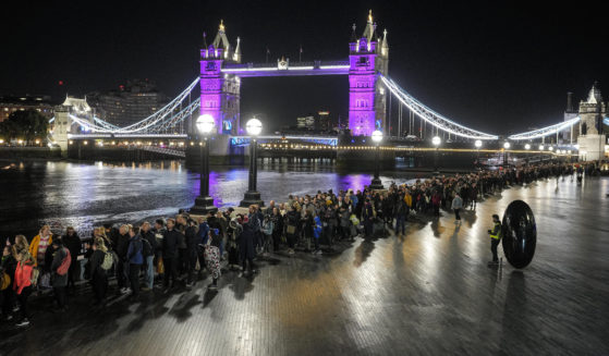 People queue in front of London's Tower Bridge early Saturday morning to pay their respects to the late Queen Elizabeth II at Westminster Hall. Waiting time in the queue has stretched to as long as 24 hours.