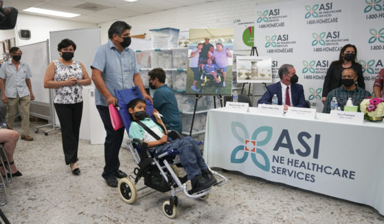 In this photo provided by Clifford Law Offices, Karina Aguilar, her husband, Temo, and their son Felipe attend a news conference on Aug. 3, 2021, at the office of ASI/NE Healthcare Services in Chicago.