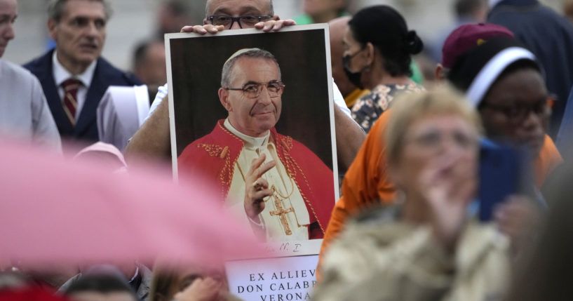 A man holds up a photograph of Pope John Paul I during his beatification ceremony in St. Peter's Square at the Vatican on Sunday.