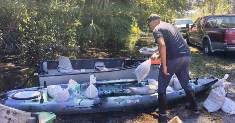 On Sunday, Gabriel Madling, a resident of Seminole County, Florida, loads sandbags into a kayak, so he can fortify his house from floodwaters left behind by Hurricane Ian.