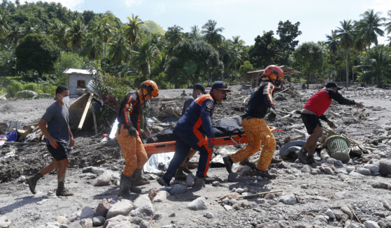 On Sunday, rescuers carry the body of a victim of mudslide in Maguindanao's Datu Odin Sinsuat town, Philippines.