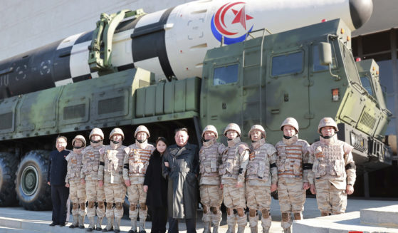 North Korean leader Kim Jong Un, center, and his daughter, center left, pose with soldiers in front of the Hwasong-17 intercontinental ballistic missile in North Korea.